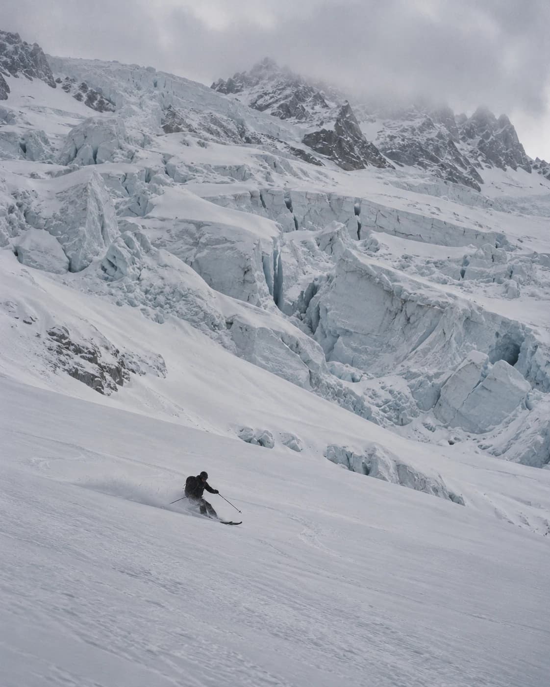 A skier turning on the Glacier du Géant, seracs behind