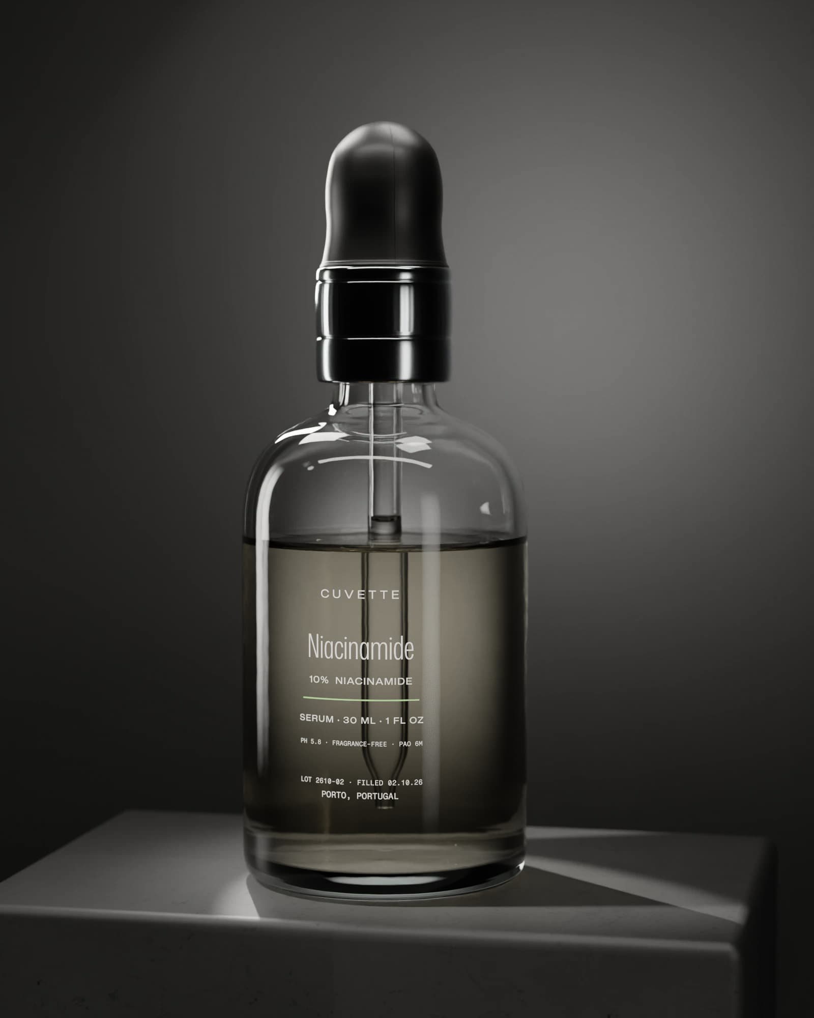 Niacinamide 10% serum in a glass dropper bottle on a basalt plinth under a single light