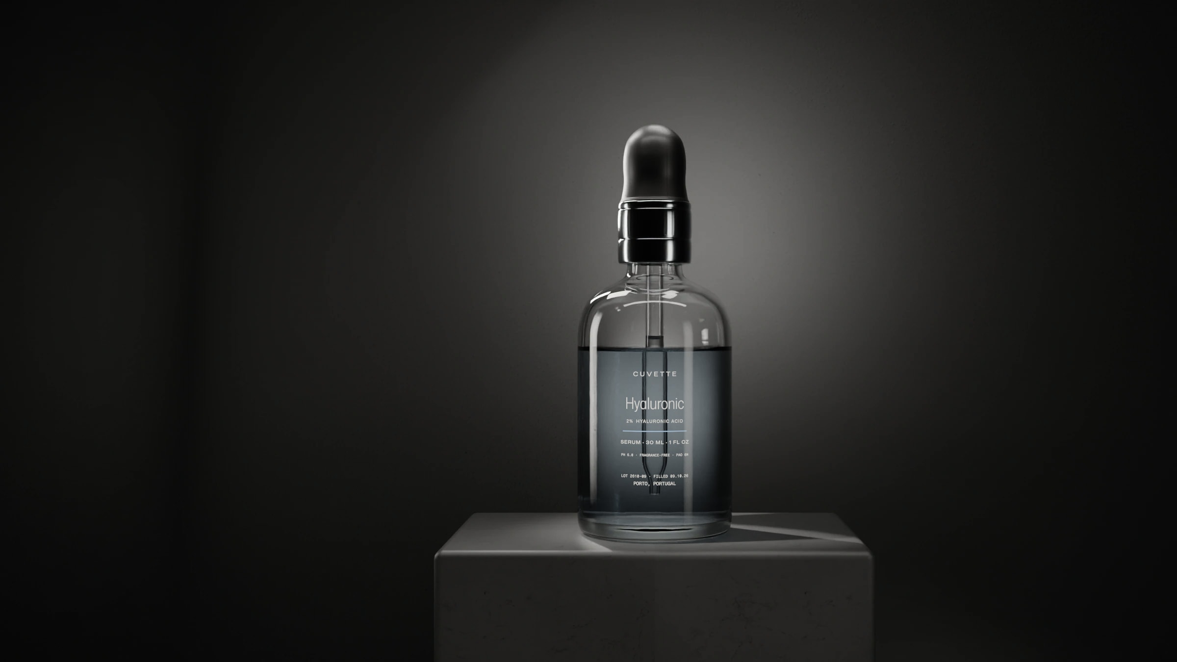 Hyaluronic 2% serum in a glass dropper bottle on a basalt plinth under a single light