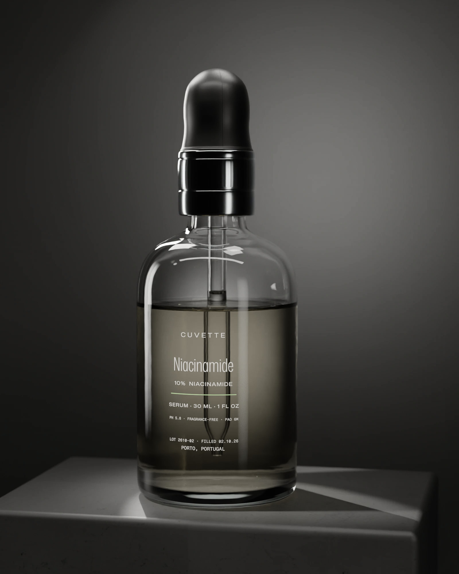 Niacinamide 10% serum in a glass dropper bottle on a basalt plinth under a single light