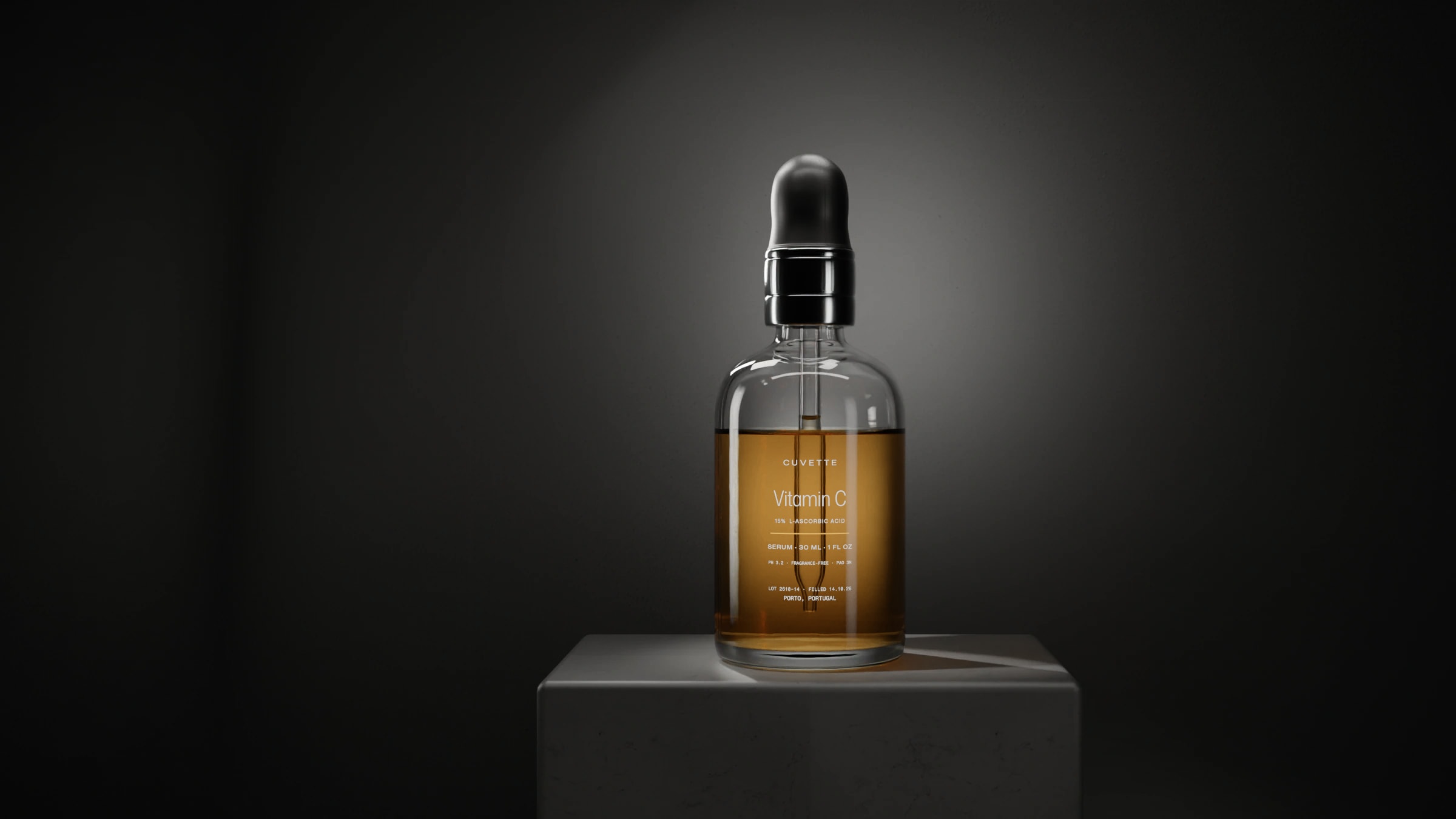 Vitamin C 15% serum in a glass dropper bottle on a basalt plinth under a single light