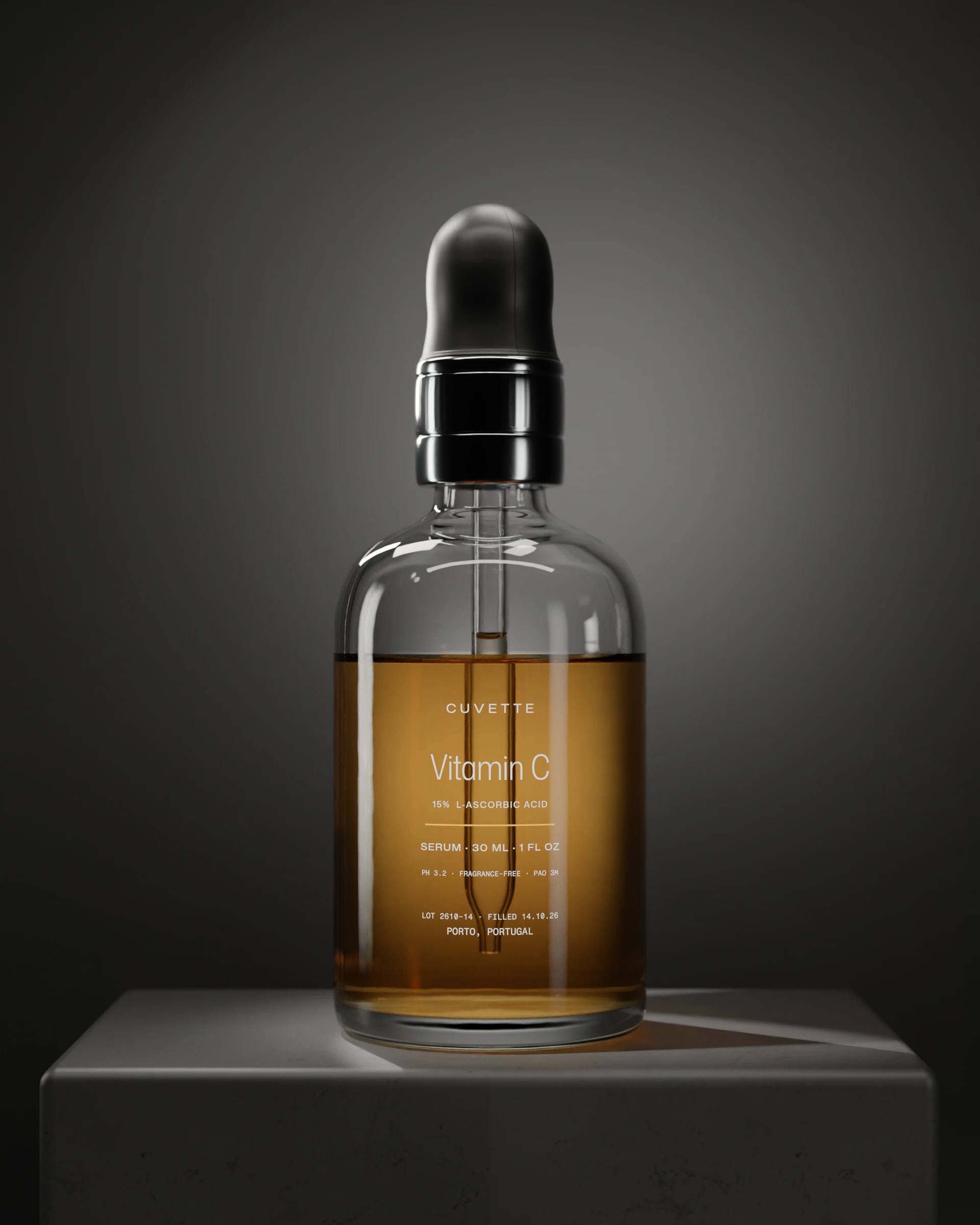 Vitamin C 15% serum in a glass dropper bottle on a basalt plinth under a single light